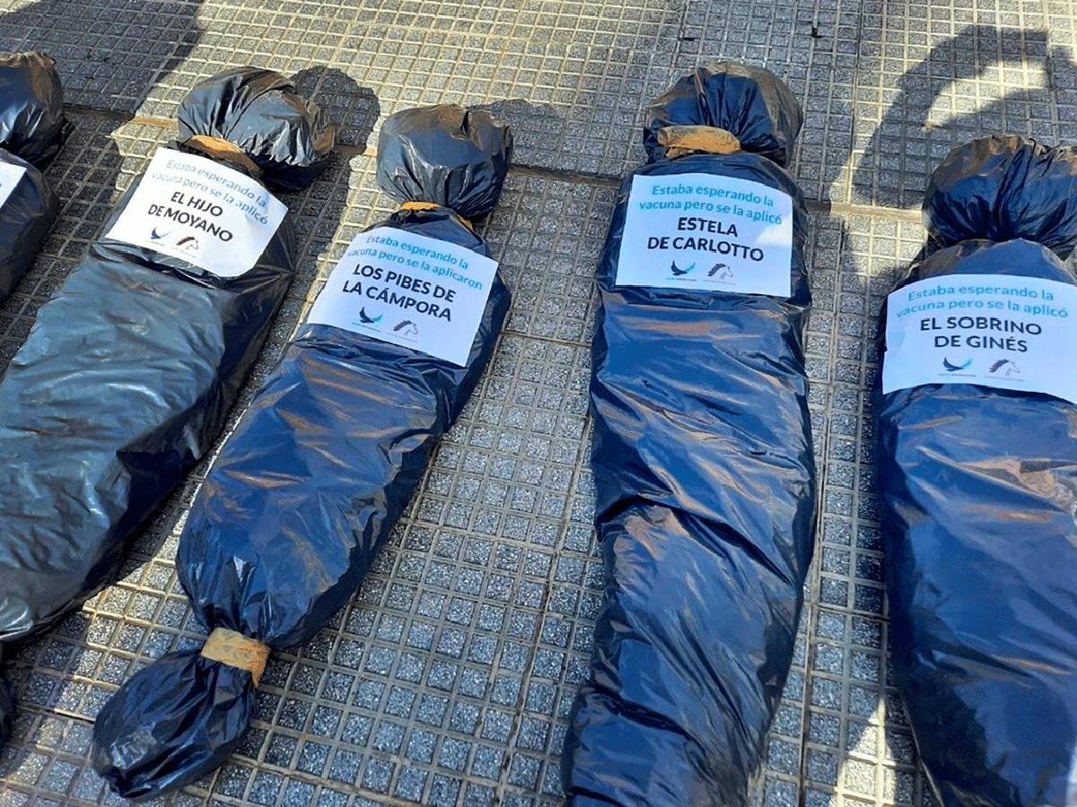 Participantes de la marcha contra la vacunación VIP colocara simulacros de cadáveres frente a la casa Rosada