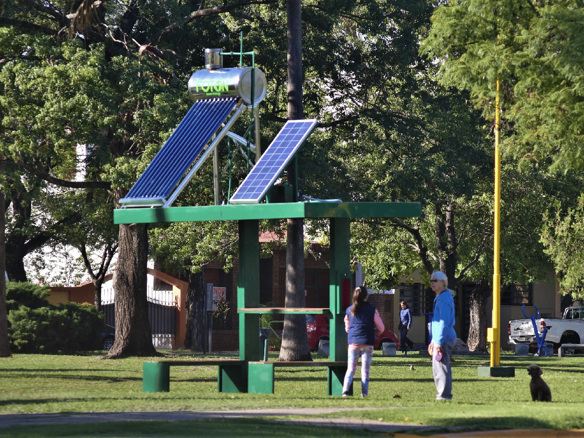 Una estación de energía solar en la plaza para agua caliente y recargar celulares   