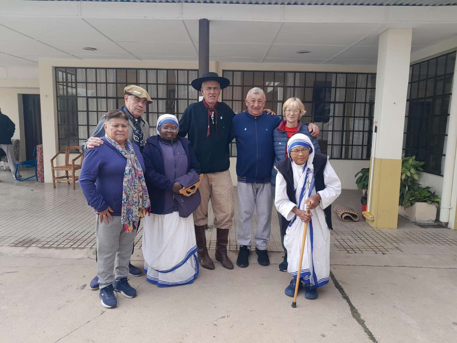 Los miembros de la agrupación El Matrero junto a los monjas del hogar que recibió la donación